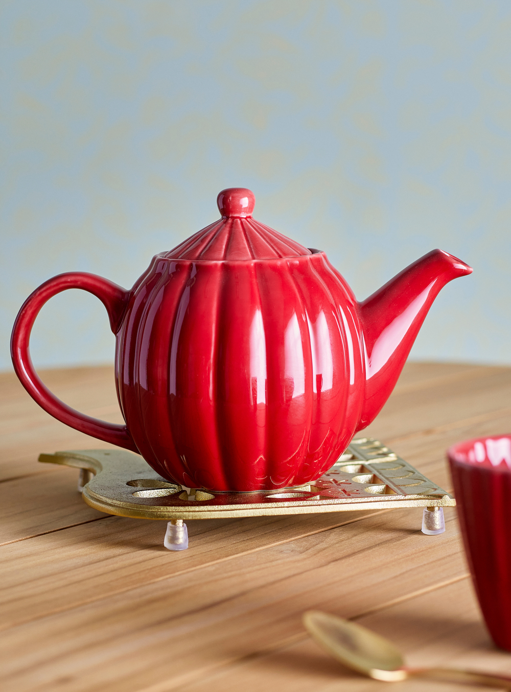 Rote Steingut-Teekanne mit vertikaler Struktur