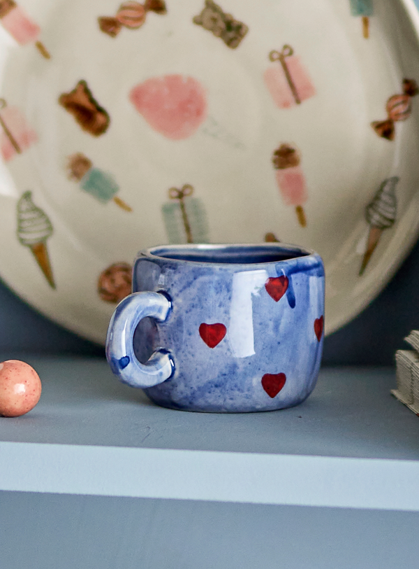 Blaue Steingut-Tasse mit roten Herzchen